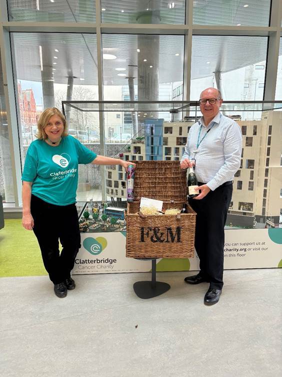 Duncan Armfield, General Manager at the Clatterbridge Private Clinic, presents Lesley Woodhead from the Clatterbridge Cancer Charity with a Fortnum and Mason hamper for the charity raffle. 